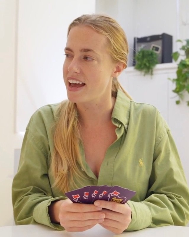 Marte aan tafel met kaarten van het Manipuliefde Kwartet in haar hand
